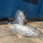 Water gushing from a burst pipe onto the driveway of a Gold Coast property