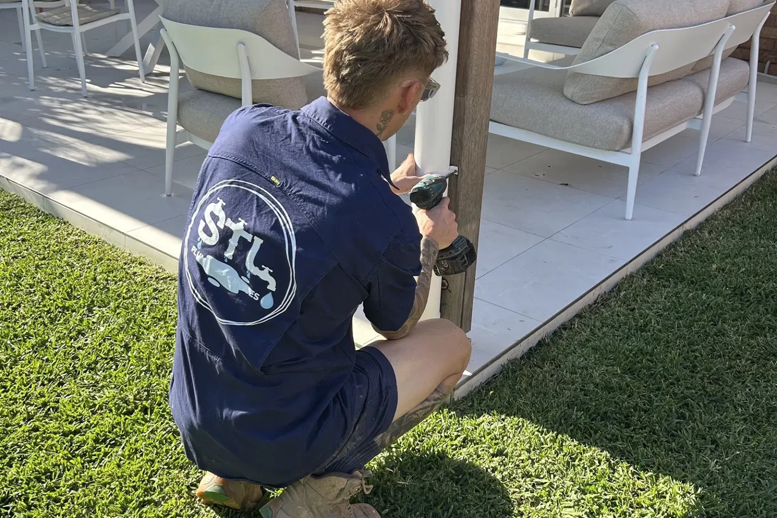 Licenced Plumber Sam Lennox is Attaching a downpipe to an outdoor patio area, Renovation Plumbing on the Gold Coast