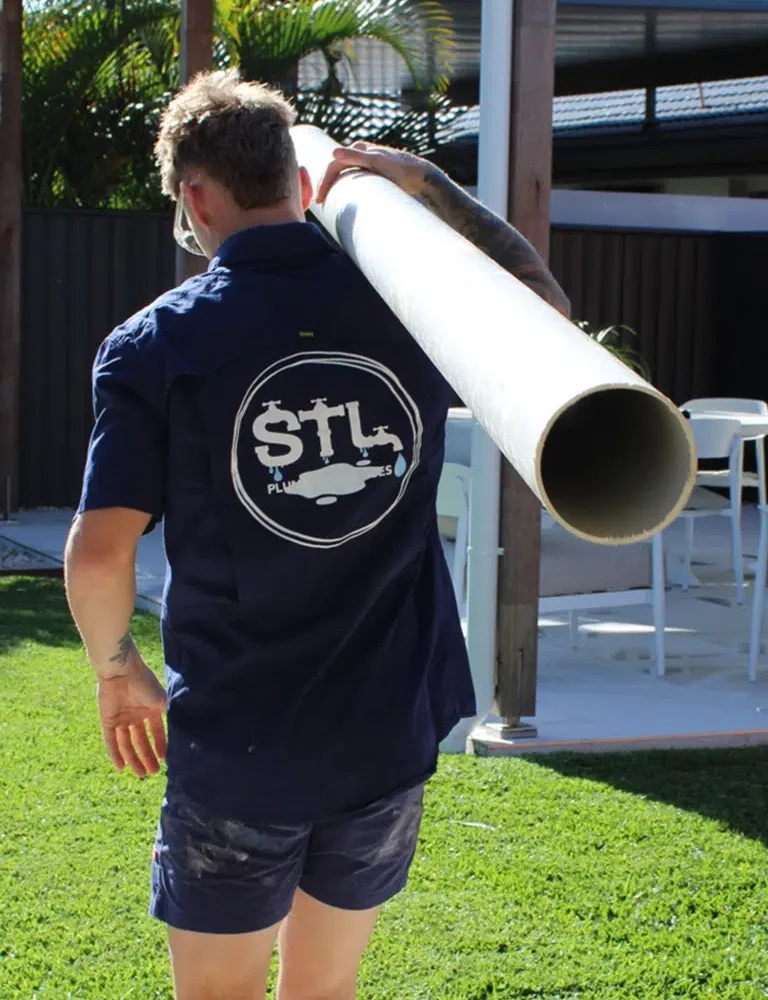 Expert Plumber Sam Lennox carrying PVC plumbing pipe to fix Blocked Drains on the Gold Coast