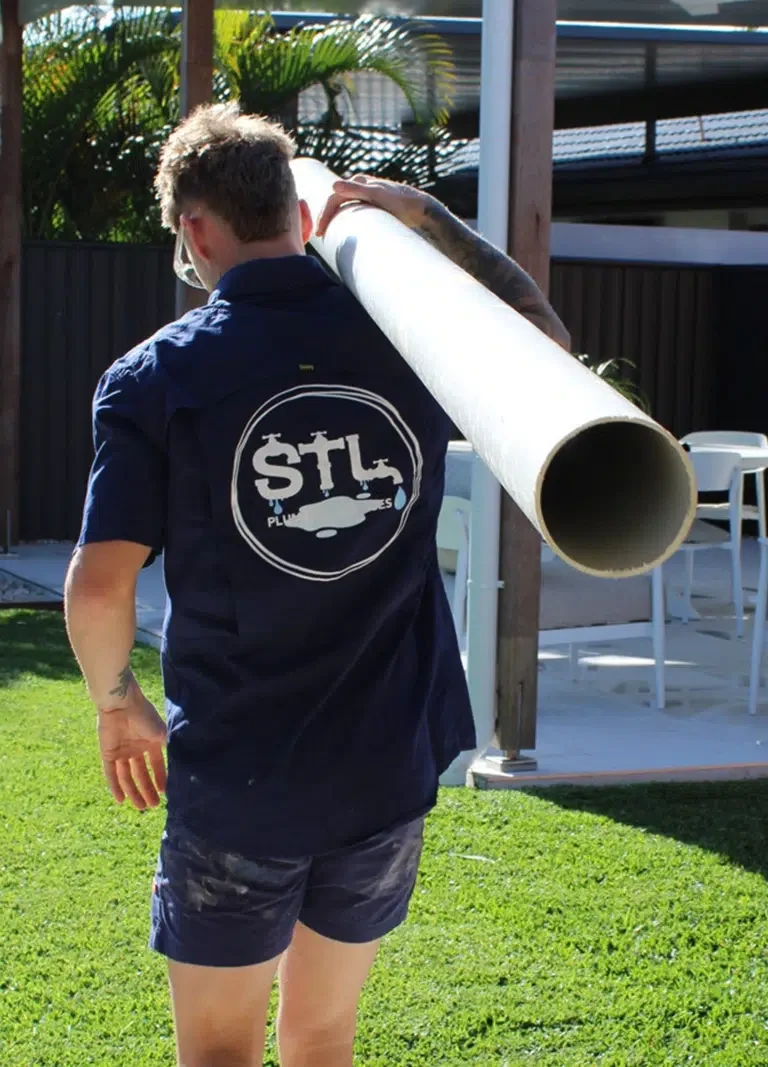 Expert Plumber Sam Lennox carrying PVC plumbing pipe to fix Blocked Drains on the Gold Coast