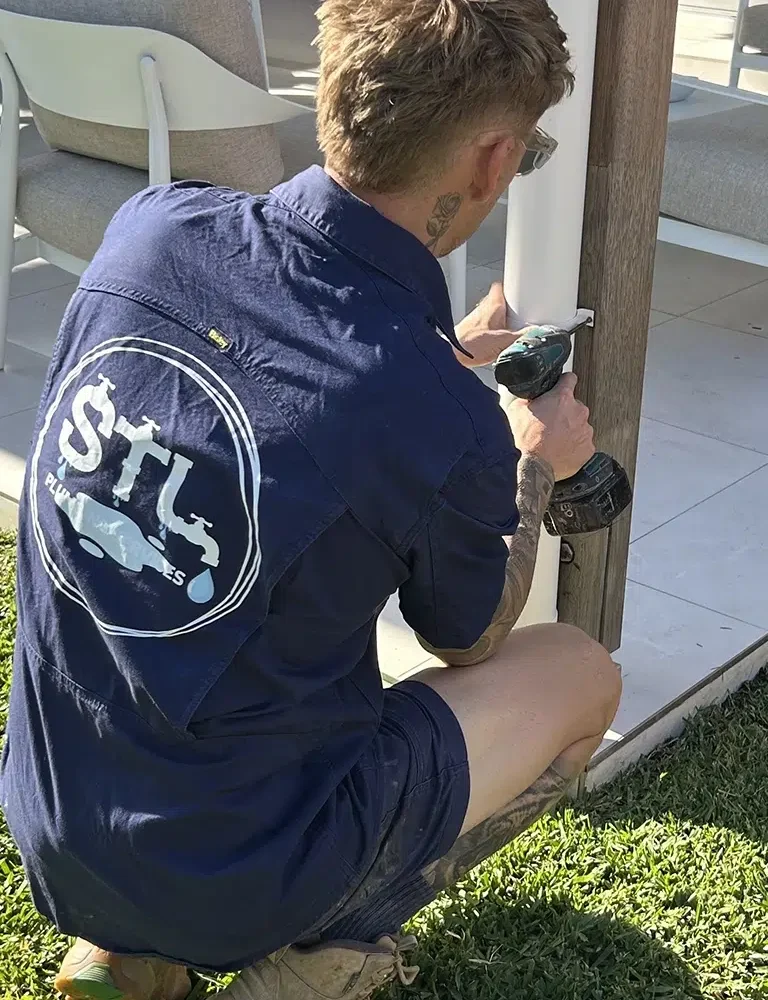 Licenced Plumber Sam Lennox is Attaching a downpipe to an outdoor patio area, Renovation Plumbing on the Gold Coast